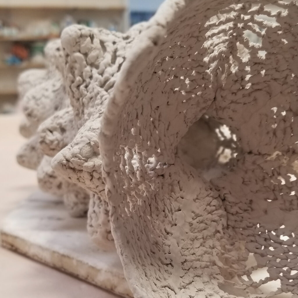 Bisque ceramic of hand knit piece that resembles a prickly-like worm